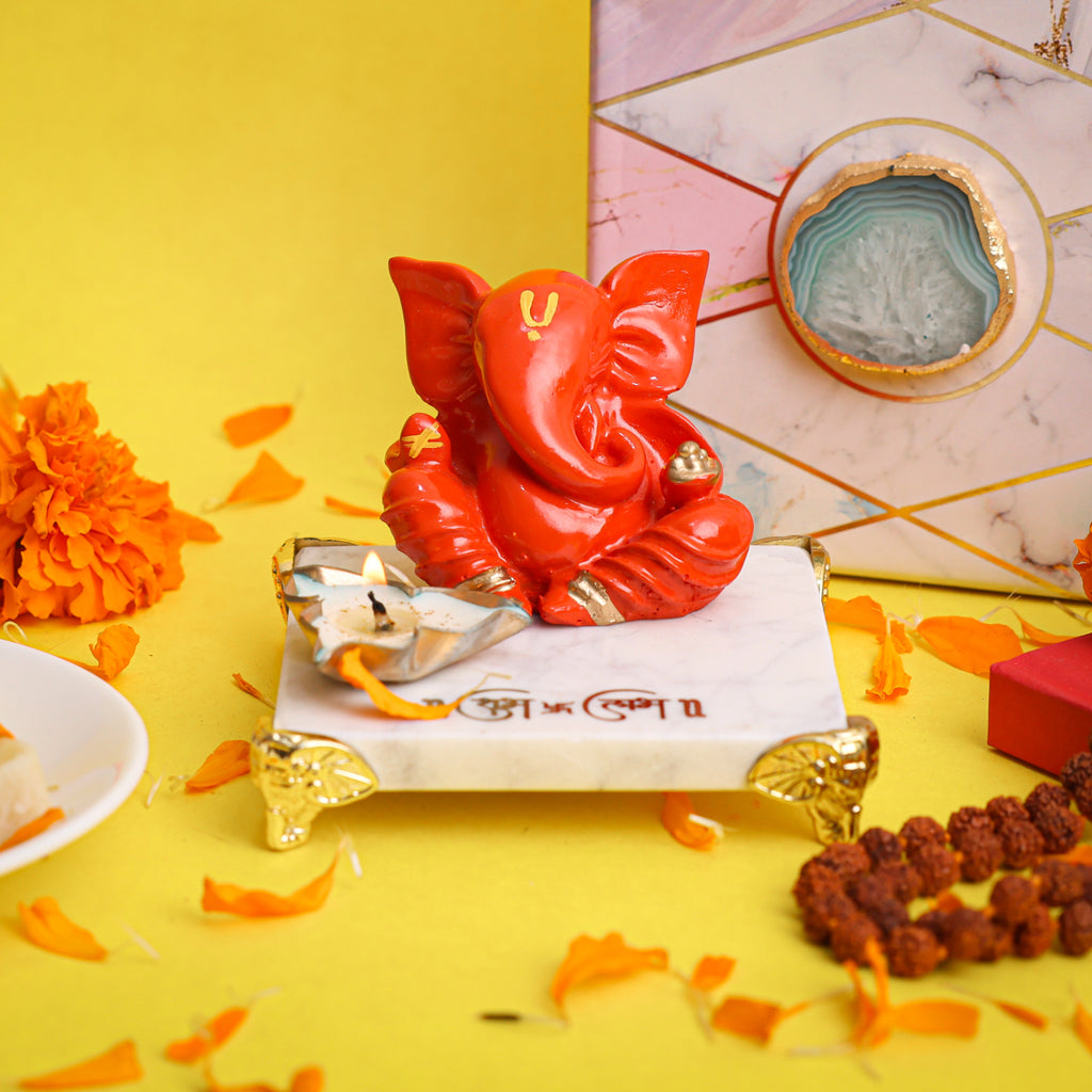 Orange Ganesha With Marble Choki And Candles